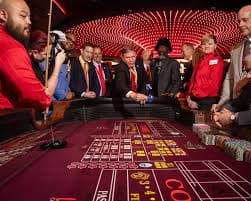 Dealer topwin303 dalam sesi Andar Bahar langsung dengan kartu berwarna dan meja hijau standar kasino